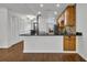 Open-concept kitchen with black countertops, wood cabinetry, stainless appliances, and pantry closet at 700 Melrose Ave J 1 Ave # J1, Winter Park, FL 32789