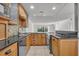Well-lit kitchen featuring wood cabinetry, granite countertops, stainless appliances, and mosaic tile backsplash at 700 Melrose Ave J 1 Ave # J1, Winter Park, FL 32789
