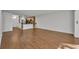 Spacious living room with wood-look tile flooring, leading to the kitchen area with breakfast bar at 700 Melrose Ave J 1 Ave # J1, Winter Park, FL 32789