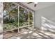 Spacious sunlit living area featuring a wall of windows with tranquil garden views at 700 Melrose Ave J 1 Ave # J1, Winter Park, FL 32789