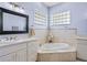 Bathroom features a soaking tub, double vanity, and tiled floors at 5155 Lake Deeson Woods Ct, Lakeland, FL 33805