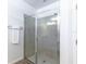 Bathroom featuring a walk-in shower with tiled walls, glass doors, and modern fixtures and white towel at 992 Jetway St, Orange City, FL 32763