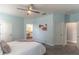 Bright bedroom featuring light blue walls, a ceiling fan, and access to a modern en-suite bathroom at 992 Jetway St, Orange City, FL 32763