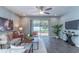 Bright living room featuring a ceiling fan, wood-look floors, and sliding glass doors to the backyard at 992 Jetway St, Orange City, FL 32763