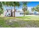 White house with a large yard and palm trees at 216 N Saint Clair Abrams Ave, Tavares, FL 32778