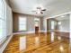 Living room showcasing gleaming hardwood floors and a ceiling fan at 216 N Saint Clair Abrams Ave, Tavares, FL 32778