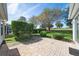 Private backyard with a brick patio, lush landscaping, and views of the surrounding golf course at 16950 Se 80Th Bellavista Cir, The Villages, FL 32162