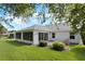 The backyard has a screened-in porch, patio and is enhanced by mature trees and lush green grass at 16950 Se 80Th Bellavista Cir, The Villages, FL 32162