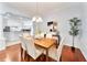 Elegant dining room featuring hardwood floors, stylish chandelier, and an open view to the kitchen at 16950 Se 80Th Bellavista Cir, The Villages, FL 32162