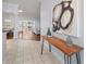 Inviting foyer with decorative table, modern art, tile flooring, and an open view to the home's living spaces at 16950 Se 80Th Bellavista Cir, The Villages, FL 32162