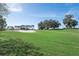 Scenic view of the golf course, showing the manicured green lawn, sand traps and mature trees at 16950 Se 80Th Bellavista Cir, The Villages, FL 32162