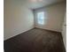 Spacious bedroom with neutral carpeting and a window at 2004 Red Rock Rd, New Smyrna Beach, FL 32168