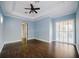 Large bedroom with hardwood floors, blue walls, and a sliding glass door with plantation shutters at 8162 Via Bella Notte, Orlando, FL 32836
