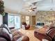 Spacious living room with a stone fireplace, hardwood floors, and sliding doors to the patio at 104 E Berkshire Cir, Longwood, FL 32779