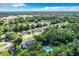 Aerial view of a neighborhood surrounded by trees and featuring a community pool at 1624 Rivers Edge Dr, Orlando, FL 32825