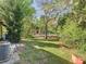 Expansive backyard with lush greenery and a pool area visible in the distance at 1624 Rivers Edge Dr, Orlando, FL 32825