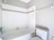 Bathroom featuring a tiled bathtub and a white toilet at 1624 Rivers Edge Dr, Orlando, FL 32825