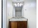 Bathroom featuring a vanity with a granite countertop, wood cabinets, and a mirror at 1624 Rivers Edge Dr, Orlando, FL 32825