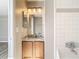 Bathroom with a single sink vanity, granite countertop, framed mirror, and a tiled shower/tub at 1624 Rivers Edge Dr, Orlando, FL 32825