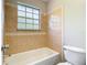 Bathroom featuring tile tub and window at 1624 Rivers Edge Dr, Orlando, FL 32825