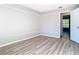 Well-lit bedroom featuring wood floors, a neutral color scheme, and an open doorway at 1624 Rivers Edge Dr, Orlando, FL 32825