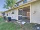Home's rear exterior with a screened-in porch and access to the backyard, including AC units at 1624 Rivers Edge Dr, Orlando, FL 32825