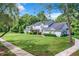 Charming front exterior view with a well-maintained lawn and mature trees at 1624 Rivers Edge Dr, Orlando, FL 32825