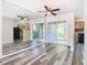 Open-concept living area featuring modern flooring, mirrored wall, and sliding glass doors to a screened patio at 1624 Rivers Edge Dr, Orlando, FL 32825