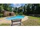 Community pool with a bench, adjacent pool house, surrounded by mature trees and landscaping at 1624 Rivers Edge Dr, Orlando, FL 32825