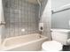 Cozy bathroom featuring a shower-tub combination with tiled walls and a white toilet at 6682 Sw 106Th Ln, Ocala, FL 34476