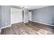 Bedroom with a spacious closet, wood-look flooring, and freshly painted light gray walls at 6682 Sw 106Th Ln, Ocala, FL 34476