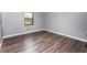 Cozy bedroom featuring wood flooring, a window, and neutral paint at 6682 Sw 106Th Ln, Ocala, FL 34476