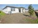 A white home with a backyard, patio, and newly planted tree at 527 Kennedy Dr, Lake Alfred, FL 33850