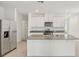 Well-lit kitchen featuring stainless steel appliances, white cabinetry, and granite countertops at 527 Kennedy Dr, Lake Alfred, FL 33850