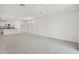 View of the open floor plan featuring carpet in the living room and tile in the adjacent kitchen at 527 Kennedy Dr, Lake Alfred, FL 33850