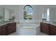 The primary bathroom boasts dual sinks, a soaking tub, white tile, and a large window at 5509 Meadow Hill Loop, Lady Lake, FL 32159