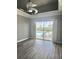 A stylish bedroom with a pool view, gray walls, dark wood flooring, and ceiling fan at 5509 Meadow Hill Loop, Lady Lake, FL 32159