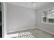 Bright bedroom features a white ceiling fan, a window with shutter blinds, and light gray walls at 5509 Meadow Hill Loop, Lady Lake, FL 32159