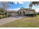 Beautifully landscaped home featuring a three-car garage and paver driveway at 5509 Meadow Hill Loop, Lady Lake, FL 32159