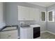 A laundry room with modern washer and dryer, utility sink, and ample cabinet space at 5509 Meadow Hill Loop, Lady Lake, FL 32159