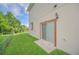 View of the backyard with a sliding glass door, small patio and a green lawn at 821 E Story Rd, Winter Garden, FL 34787