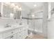 Bright bathroom featuring double sink vanity, sleek fixtures, and a shower with glass door at 821 E Story Rd, Winter Garden, FL 34787