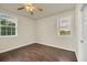 This bedroom features wood-look floors, a ceiling fan, and natural light from two windows at 821 E Story Rd, Winter Garden, FL 34787