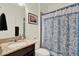 Well-lit bathroom featuring a granite vanity, a toilet, and a shower with a patterned curtain and modern fixtures at 5232 Villa Rosa Ave, St Cloud, FL 34771
