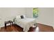 Serene bedroom with hardwood floors, a comfortable bed, and a window providing natural light and an outdoor view at 5232 Villa Rosa Ave, St Cloud, FL 34771