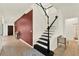 Inviting foyer with a staircase featuring black and white accents, tile floors, and a bold accent wall at 5232 Villa Rosa Ave, St Cloud, FL 34771