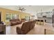 Open-concept living area with plush sofas, a ceiling fan, and a breakfast bar connecting to the modern kitchen at 5232 Villa Rosa Ave, St Cloud, FL 34771