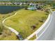 Expansive community green space featuring a playground, pool area, and scenic walking path alongside a pond at 5408 Manchester Dr, St Cloud, FL 34771
