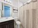Bright bathroom with single vanity, framed art, and decorative shower curtain at 8060 Cherrystone St, Leesburg, FL 34748