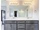 Double vanity bathroom with large mirror and walk-in shower at 8060 Cherrystone St, Leesburg, FL 34748
